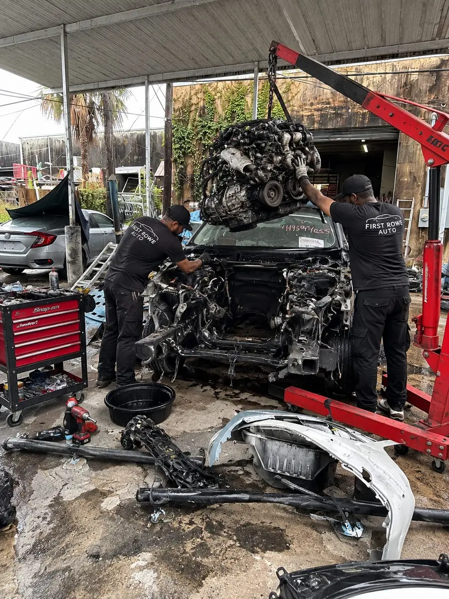 Technicians removing an engine with a hoist