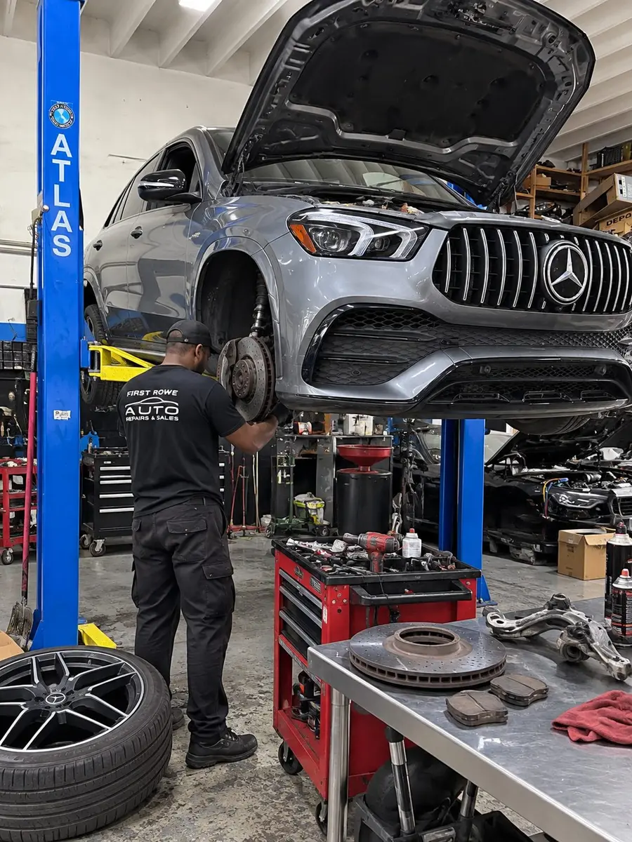 Technician working under a Mercedes-Benz GLE on a lift